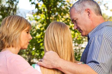 parents comforting teen about her first heartbreak